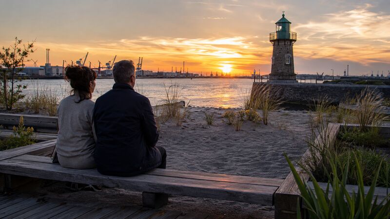 Ein Paar erlebt den Sonnenuntergang am Waller Sand in der Bremer Überseestadt