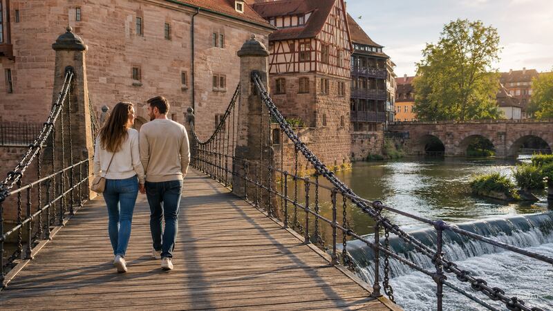 Ein Paar spaziert am Kettensteg über die Pegnitz in Nürnberg
